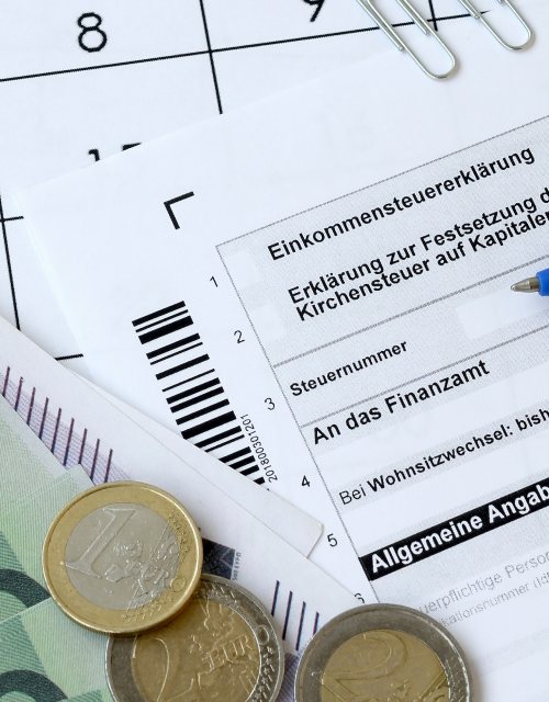 Niemiecki formularz podatkowy, długopis i monety euro
